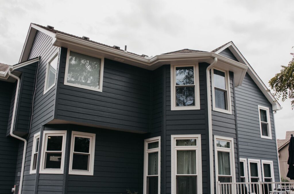 A Smart Exteriors technician applying vinyl siding in Peculiar, MO, highlighting the advantages of local skilled installation.